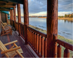 The patio of a cabin overlooking a lake