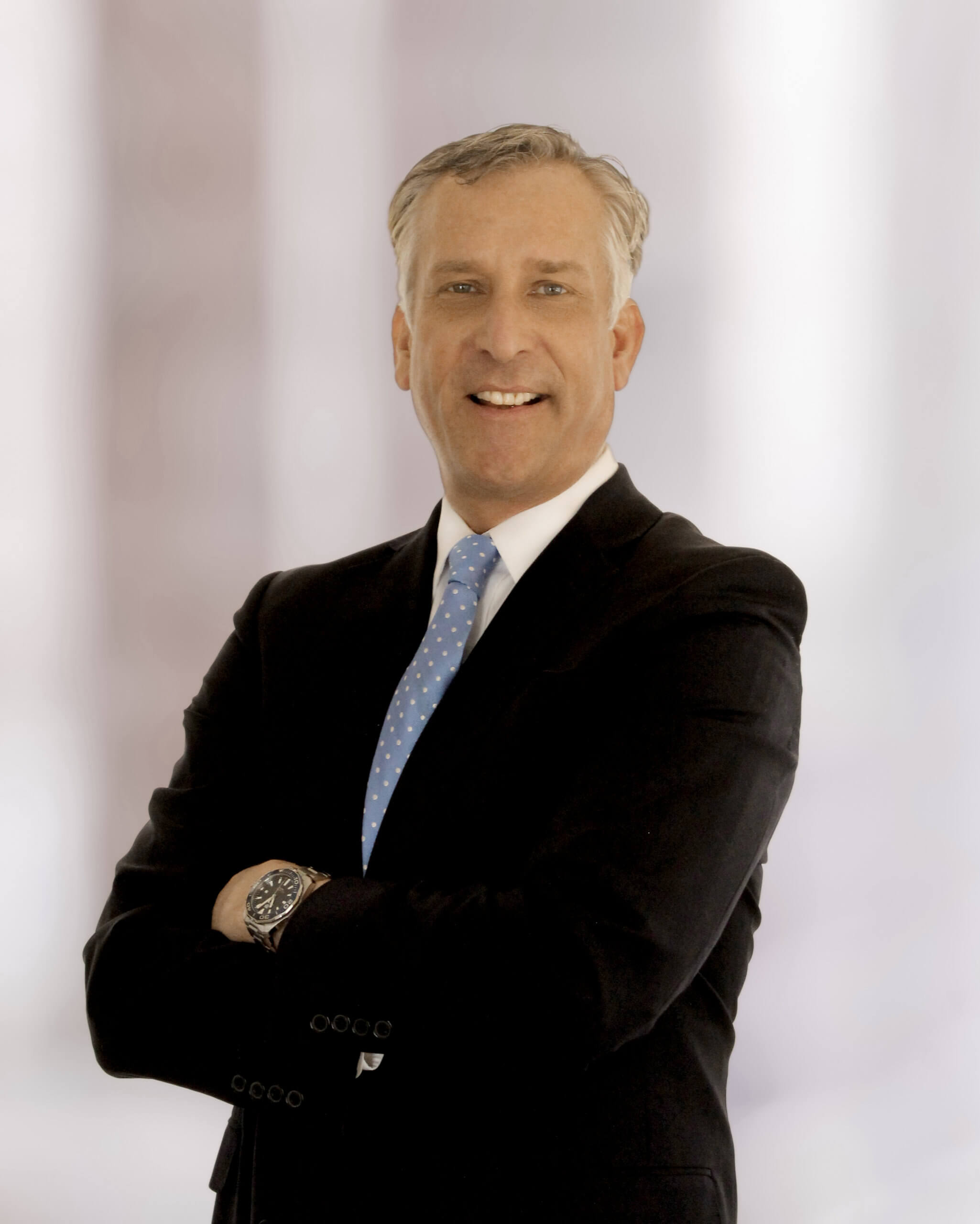 Joel P Mullen crossing arms in a suit